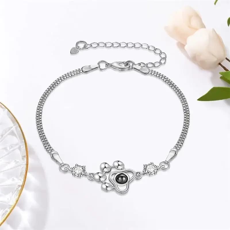 Silver-coloured box chain bracelet with a paw charm and a projected photo of a dog