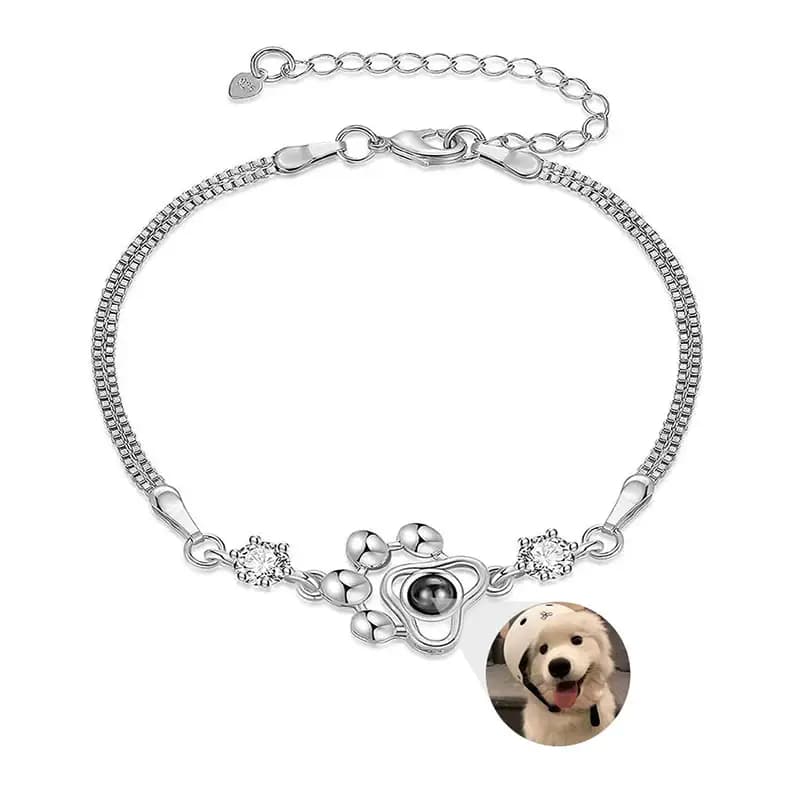 The whole bracelet laid flat: doubled box chain, lobster clasp, extender chain and the paw charm between two zircons