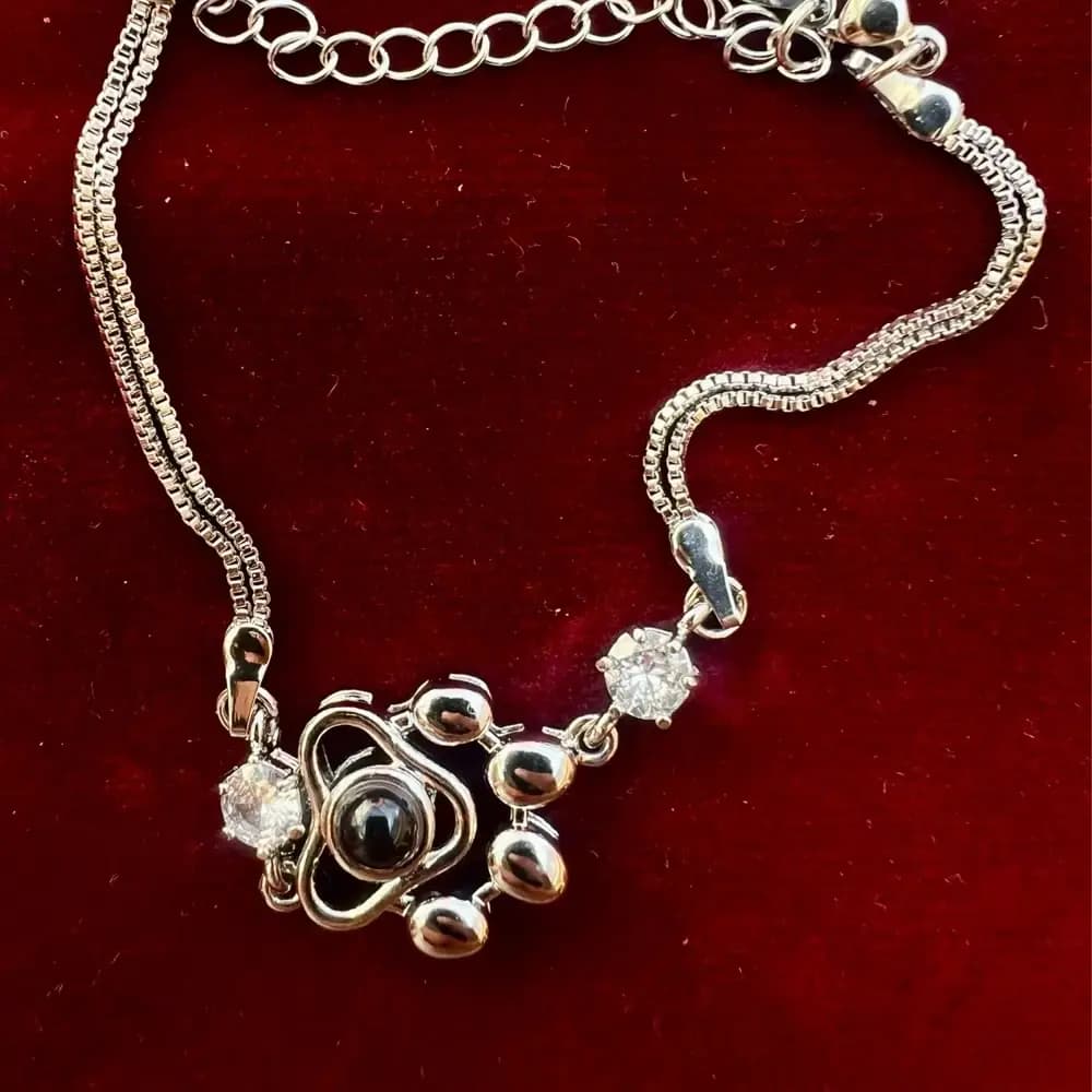 Customer photo: the bracelet on red velvet, paw charm and zircons in detail